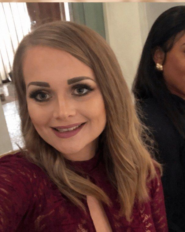 Maia a few years ago at an evening event, full makeup, straightened hair, smiling for the camera